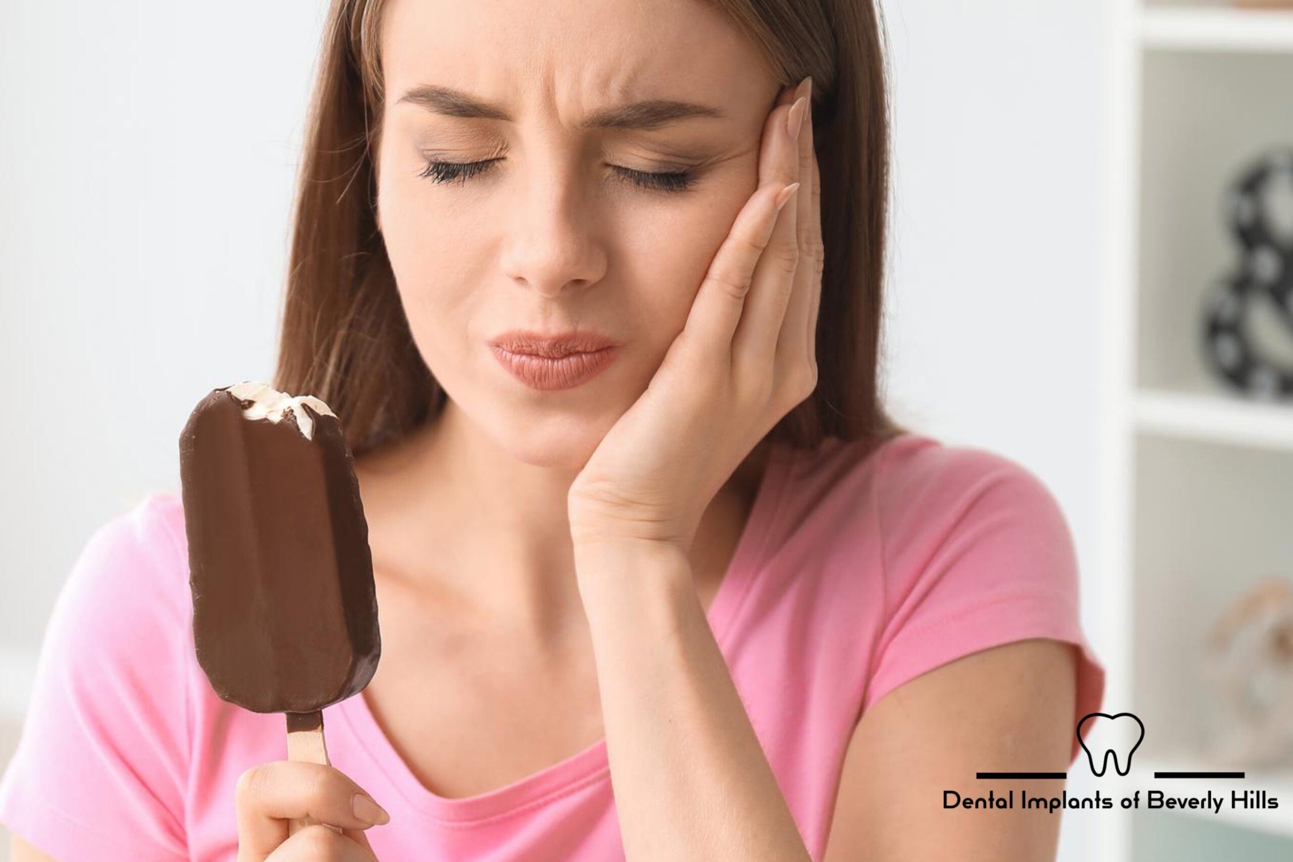Woman with tooth sensitivity from cold food