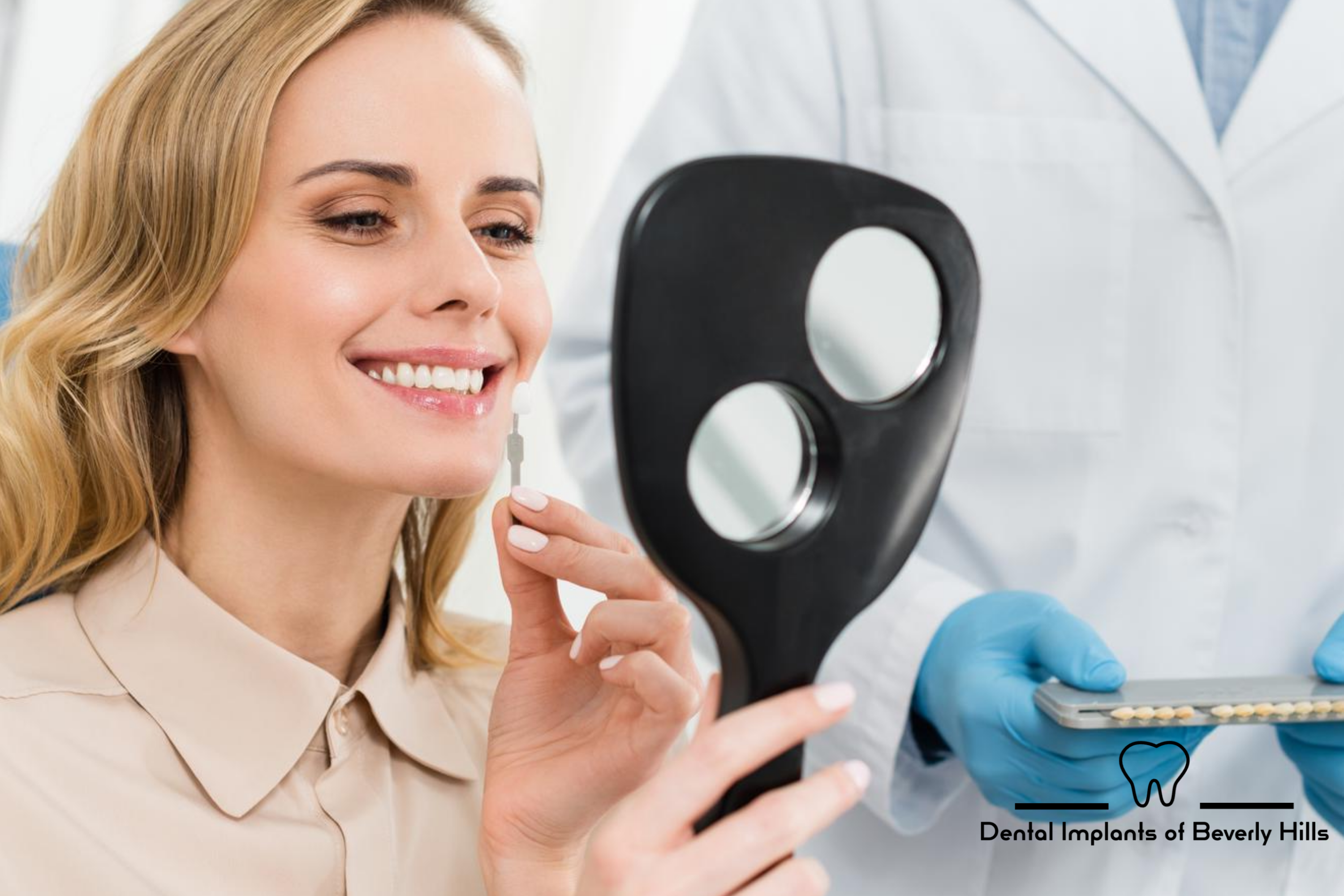 Woman looking at newly implanted dental implants in mirror by dentist in Beverly Hills